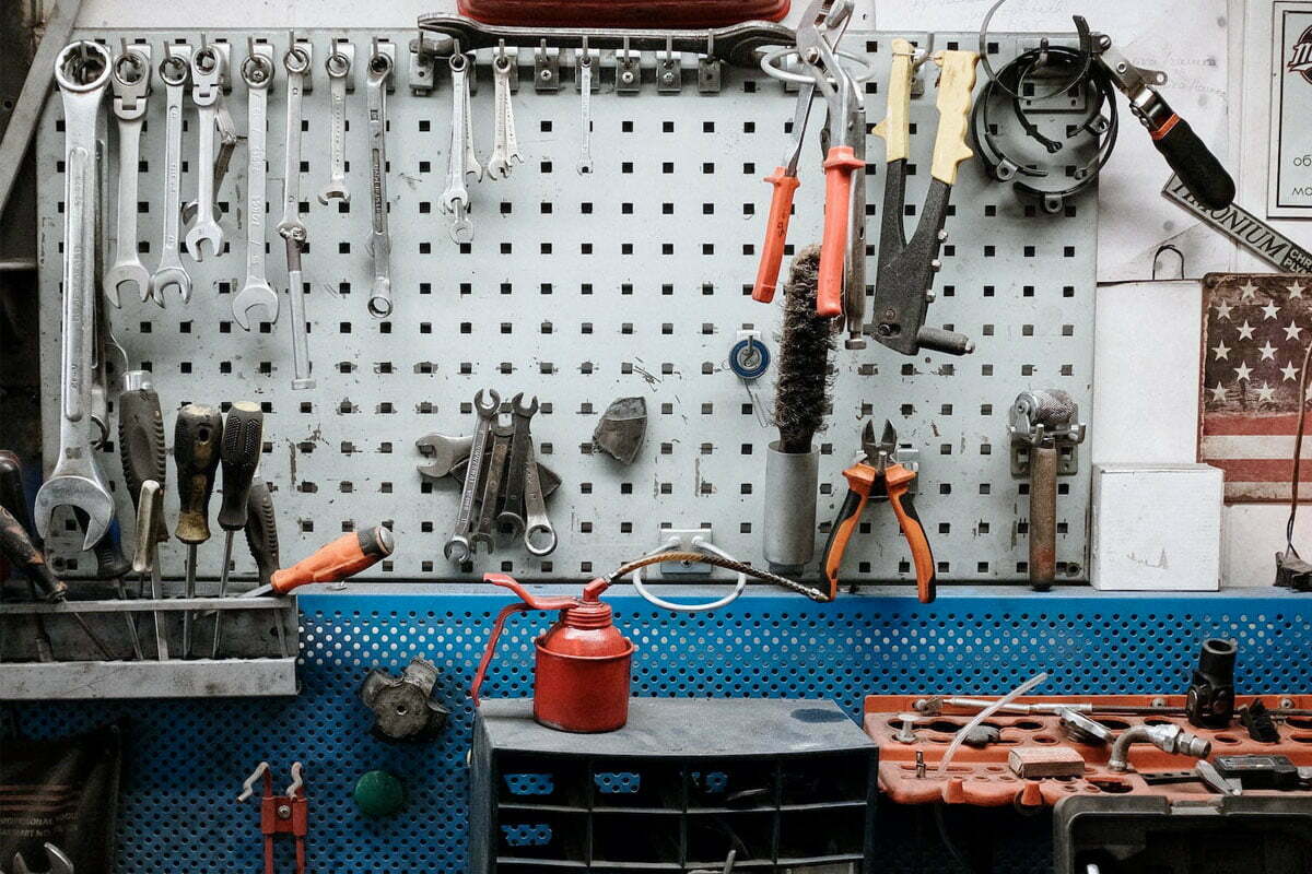 Automotive shop with different car tools like funnels, hammers, pliers, ratchets, screwdrivers, and more