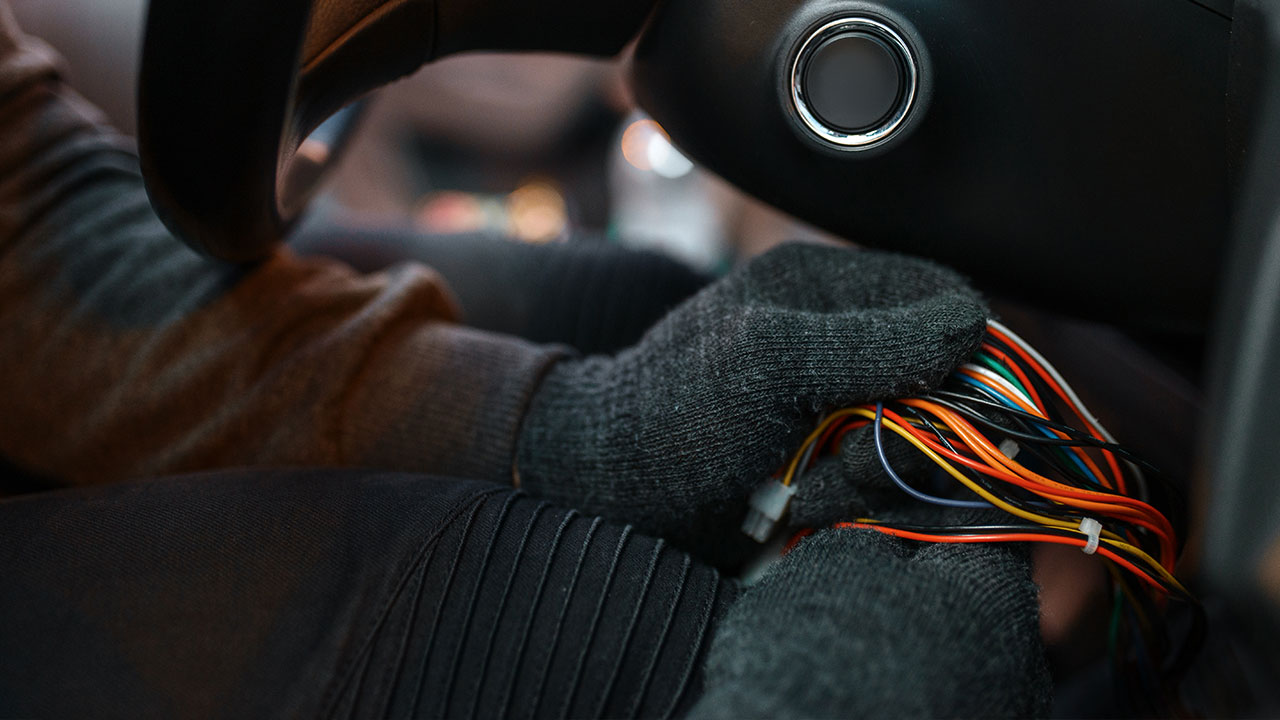 hand with gloves holding automotive electrical wires