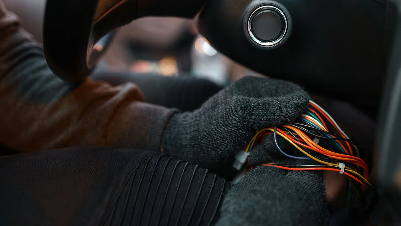 hand with gloves holding automotive electrical wires